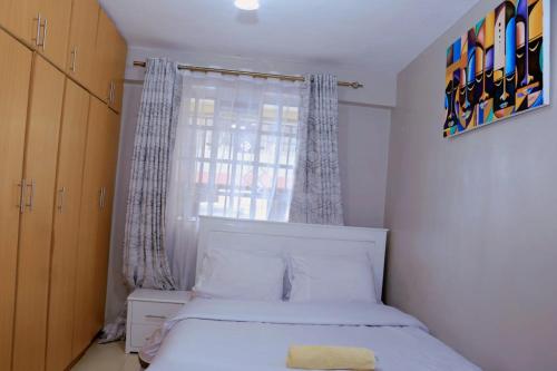 KisiiLovely 3 bedroom apartment, kisii的卧室配有白色的床和窗户。