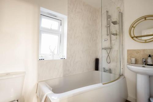 布兰德福德福鲁姆Stillness- Connect to the Nature in the Hot Tub的白色的浴室设有浴缸和水槽。
