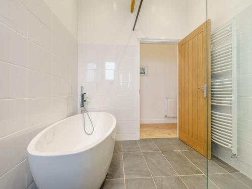 Trimdon GrangeAbigails Cottage的白色的浴室设有浴缸和玻璃门