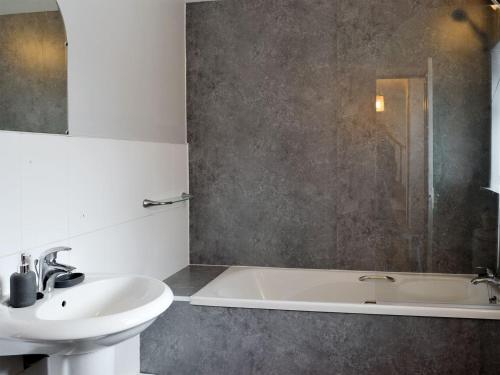 UplawmoorOld Stable Cottage的浴室配有盥洗盆和浴缸。