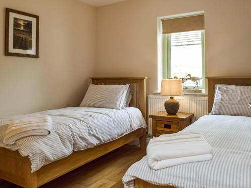 Hayscastle CrossThe Granary的一间卧室设有两张床和窗户。