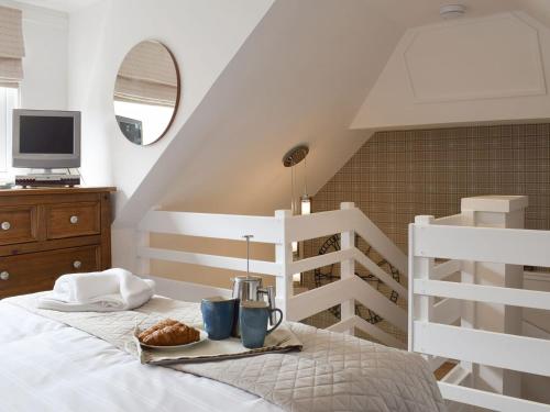 法夫Horseshoe Cottage的一间卧室配有一张床,上面放着一个食物托盘