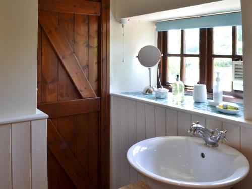 SlingsbyKates Cottage的一间带水槽和镜子的浴室以及窗户。