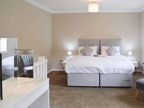 阿伯福伊尔Faodail-uk34218的卧室配有一张白色大床和一把椅子