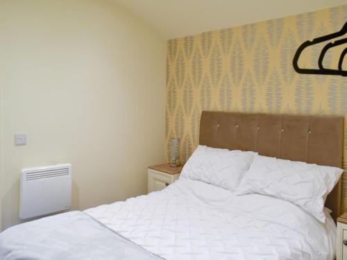 YaldingShepherds Hut 1 At Laddingford - Uk32531的卧室配有白色的床和木制床头板
