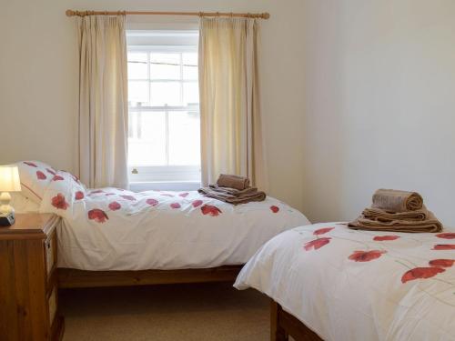 莱德伯里The Cottage的带窗户的客房内设有两张单人床。