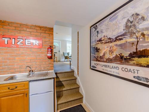 贝尔福德Millers Cottage的厨房配有水槽,墙上挂有电影海报