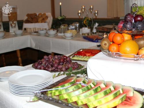 爱尔福特Hotel Garni Melchendorf的自助餐,包括桌上的水果和蔬菜