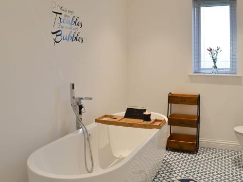 PollacharWest Kilbride的带浴缸的浴室以及笔记本电脑