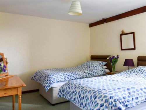 Saint EndellionStable Cottage - Uk12088的一间卧室配有两张带蓝白色床单的床