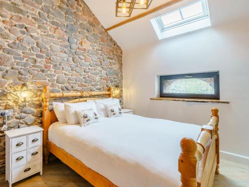 Bowness-on-SolwayThe Barnacle Goose - Uk35261的一间卧室设有石墙和一张床