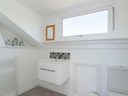 罗宾胡兹贝Edenholme的白色的厨房设有水槽和窗户