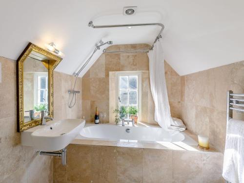 FulbeckGardeners Cottage - Uk35774的带浴缸、水槽和镜子的浴室