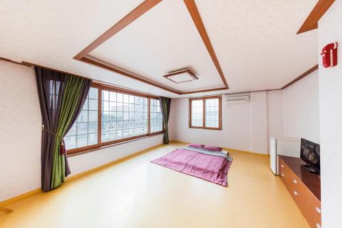 庆州Remember Youth Hostel的一间空房间,设有大窗户和一张床
