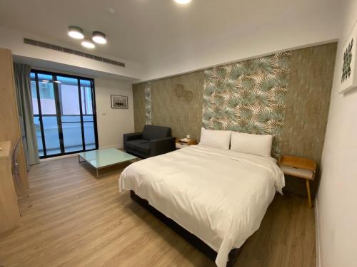 台北千彩格精品旅店的卧室配有一张白色大床和一把椅子