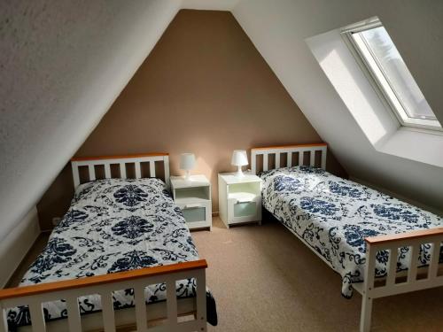 大格勒瑙Ferienhaus Groß Grönau的阁楼卧室设有两张床和两个窗户。
