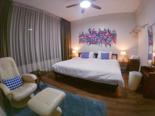 清迈Baan Nai Soi Mini Hotel的一间卧室配有一张大床和一把椅子
