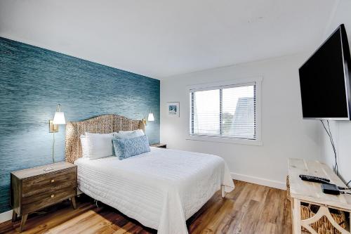 棕榈岛Oceanside 308-B的一间卧室配有一张床和一台平面电视