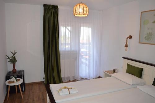 CălăţelePensiunea Anda的一间卧室设有一张大床和一个窗户。