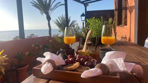 圣地亚哥海滩Casa Moni Ferienwohnung mit Meerblick的一张桌子,上面放着一盘食物和两杯橙汁