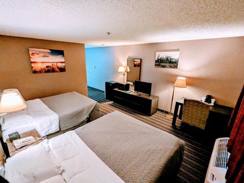 MarshfieldWoodfield Inn and Suites的酒店客房设有两张床和电视。