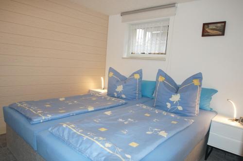 萨加尔德Ferienwohnung Schubert的一间卧室配有蓝色的床、蓝色床单和枕头
