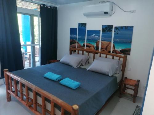 班塔延岛Villa Jana, Bantayan, Santa Fe的一间卧室配有一张带两个蓝色枕头的床