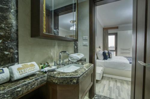 开罗LOFTS by ELEGANT的一间带水槽的浴室和一张位于客房内的床