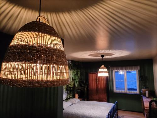 达默SWANder的一间卧室配有一张床和一个吊灯