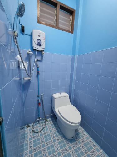 清莱หอพักโชคอนันต์的蓝色的浴室设有卫生间和淋浴。