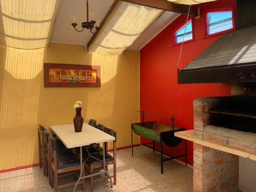 瓦尔迪维亚Casa de la Ribera Pelantaro的一间设有桌子和红色墙壁的餐厅