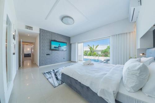 纳哈里亚אנדראה בוטיק - פנטהאוז מושלם עם בריכה פרטית וג'קוזי - Andrea Boutique Luxury Penthouse with heated pool and jacuzzi的一间卧室设有一张大床和一个大窗户