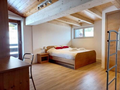 博萨迪法萨Chalet Relax的一间带一张床的卧室,位于带木制天花板的房间内