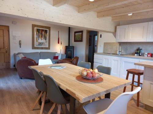 博萨迪法萨Chalet Relax的厨房以及带木桌和椅子的用餐室。