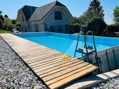 伊德里亚Apartment Sofia的一座带木甲板的游泳池,位于一座房子旁边