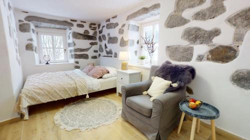 舒马瓦山区霍日采Romantická chalupa s krbem的一间小卧室,配有一张床和一把椅子