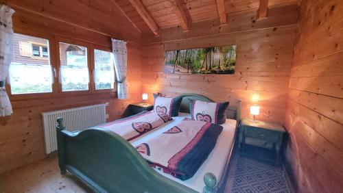 StamsriedFerienhaus Chalet Blockhaus Bayern的小木屋内一间卧室,配有一张床