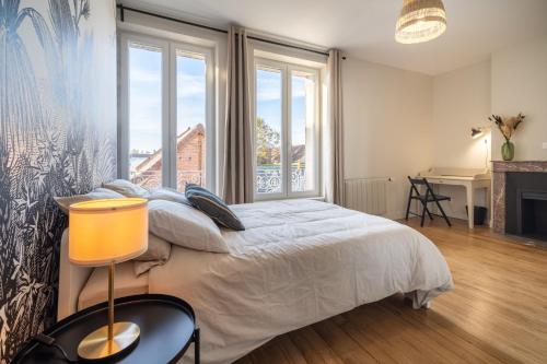 旺多姆L'Orée du Faubourg - VENDOME CENTRE的一间卧室设有一张床和一个大窗户
