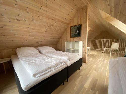 SandurOkkara summarhús á Sandi - Luxury cottage - Unique location的木制客房内的一间卧室,配有一张床