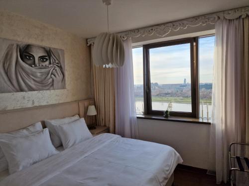 贝尔格莱德Beograd na Vodi - BW ARCADIA LUXURY的一间卧室设有一张床和一个大窗户