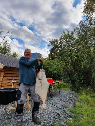 希博滕Strandbu Camping的一个人拿着一只带矛的大鱼