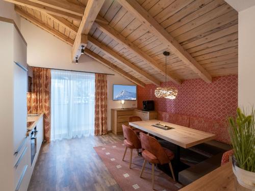 迈尔霍芬Appartements ALMA的厨房以及带木桌和椅子的用餐室。