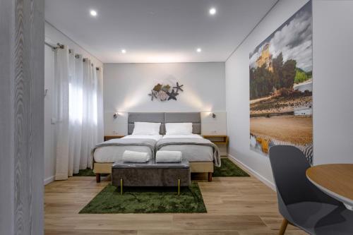 塞图巴尔Casanossa的一间卧室配有一张大床和一张桌子