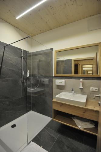 PinsdorfGasthaus Reiter的一间带玻璃淋浴和水槽的浴室