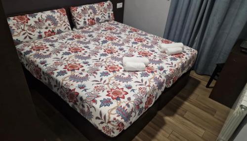 马德里corazón San Bartolomé的一张带花卉床罩的床,上面有两条毛巾