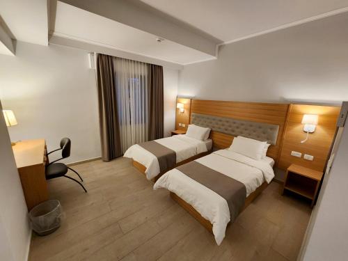 拉马拉St Andrew's Guesthouse - Ramallah的酒店客房配有两张床和一张书桌