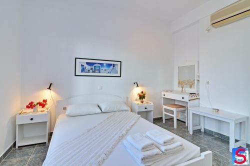 阿波罗尼亚Soultana Rooms & Studios的卧室配有白色的床和2张白色的桌子