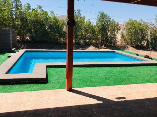 伊基克Casa con Piscina privada en Pica的绿色草地庭院中的游泳池