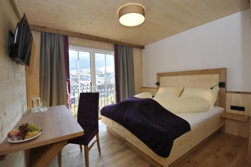 PinsdorfGasthaus Reiter的一间卧室配有一张床和一张带一盘食物的桌子