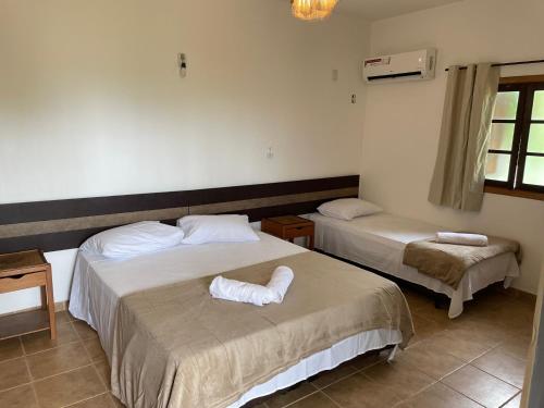 乌巴图巴Canto de Itamambuca的一间卧室配有两张带毛巾的床